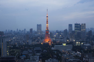 Illuminated buildings in city against sky