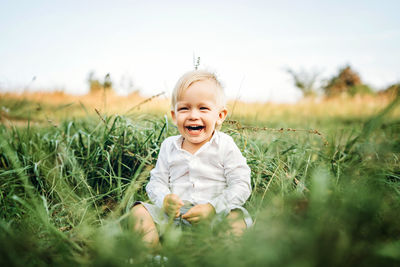 Portrait of cute boy smiling on field