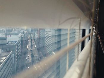 Panoramic view of city buildings seen through glass window