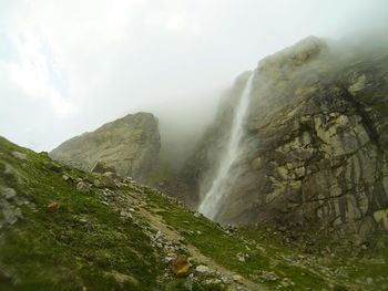 Scenic view of waterfall against sky