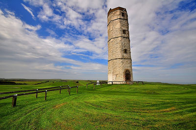 Built structure on field against sky