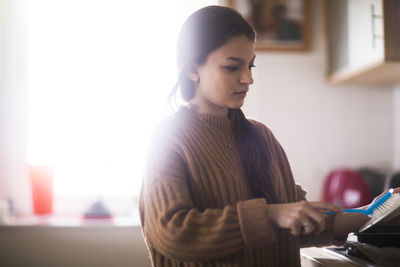 Young woman standing at home