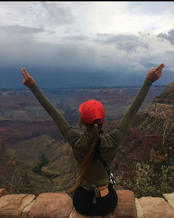 Rear view of person standing on landscape against sky