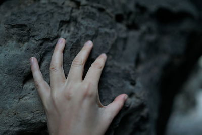 Close-up of human hand on rock