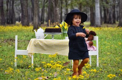 Portrait of smiling woman holding while standing on plants