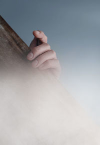 Close-up of human hand  on wood board in fog