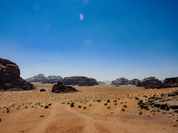 Scenic view of desert against blue sky