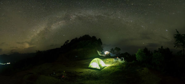 Tent on landscape against star field at night
