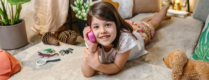 Portrait of cute girl playing with teddy bear at home