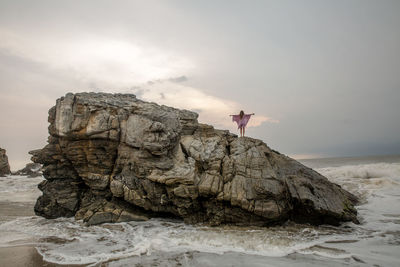 Rock formations by sea against sky