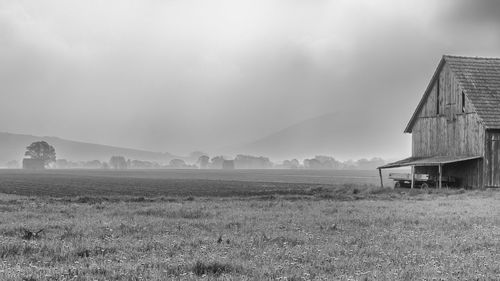 Barn on field against sky