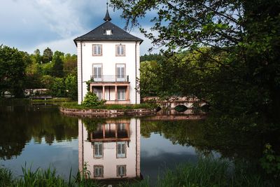 Building by lake against sky