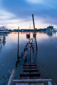 Pier over lake against sky during sunset