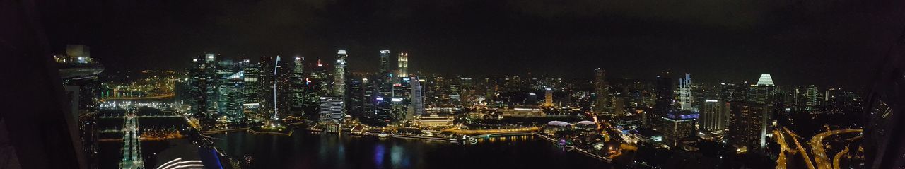 Illuminated cityscape against sky at night