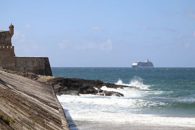 Cruise ship in sea against sky seen from forte de sao juliao da barra