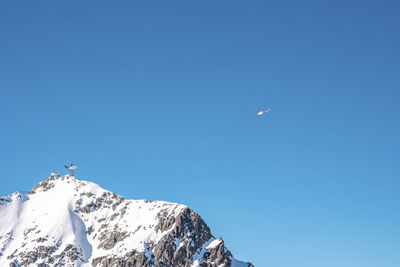Rescue helicopter flying over snowy mountain