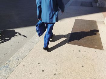 Low section of man walking on street