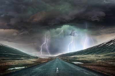 Road passing through landscape during rainy season