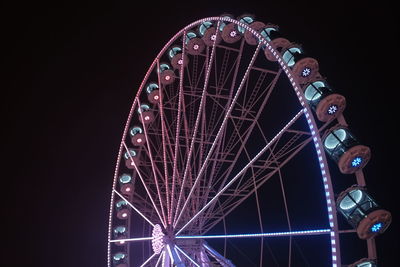 Low angle view of illuminated ferris wheel against sky at night