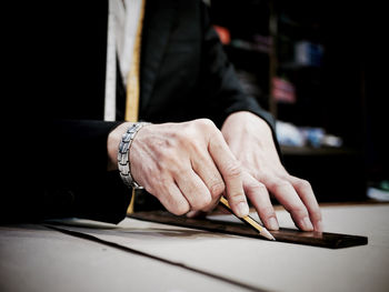 Midsection of businessman drawing with ruler in paper