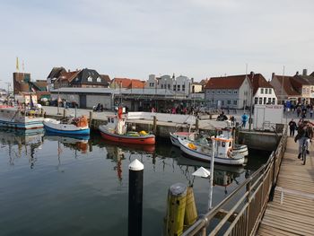 Boats moored at harbor by buildings in city