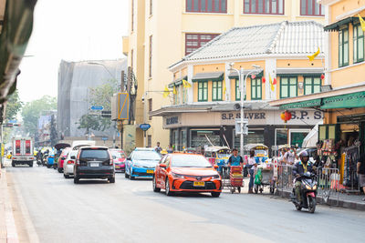 Traffic on road by buildings in city