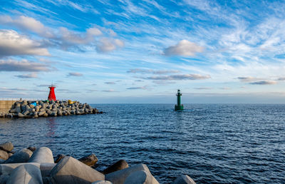 Lighthouse by sea against sky