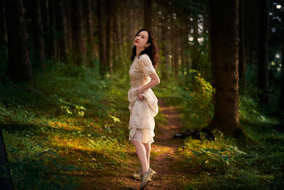 Portrait of young woman standing in forest