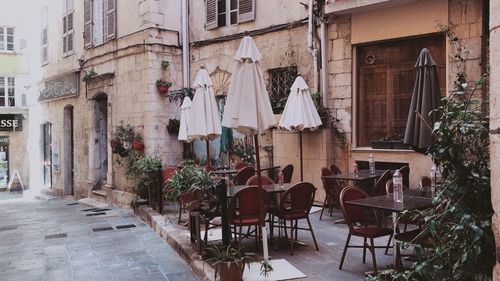 Empty chairs and tables in front of building