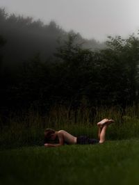 Side view of boy lying on grass