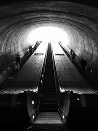 Low angle view of people on escalator at subway station