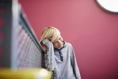 Thoughtful boy leaning on railing at middle school