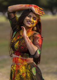 Smiling woman playing holi outdoors