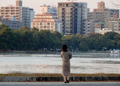 Rear view of a person standing on street against cityscape