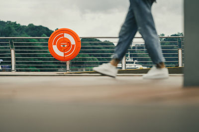 Low section of person walking by railing