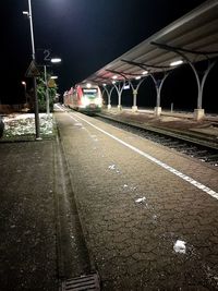 Railroad tracks against sky at night