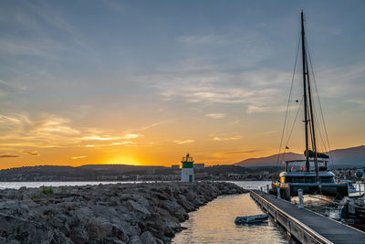 Sailboats on sea against sky during sunset