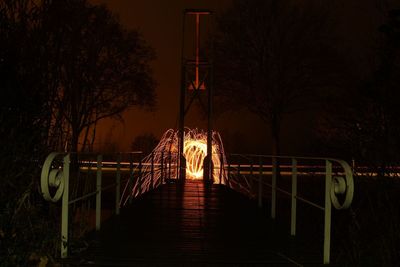 Illuminated bridge against sky at night