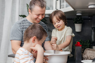 Kids helping father preparing food at home