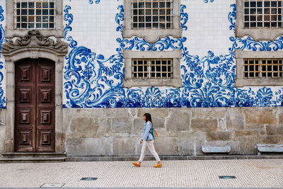 Rear view of woman standing against building