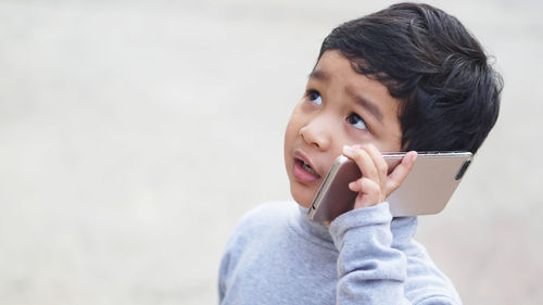Portrait of boy holding mid adult man looking away
