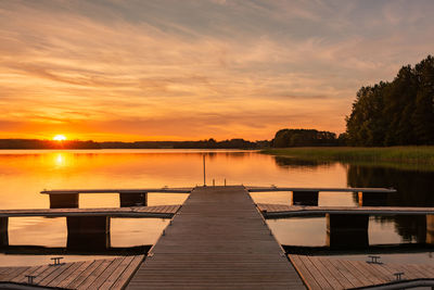 Pier over lake against sky during sunset