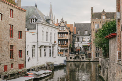 Canal amidst buildings in city against sky