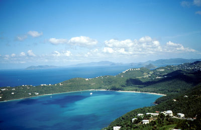 Scenic view of sea and mountains against blue sky