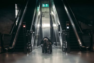 Woman with dog by escalator