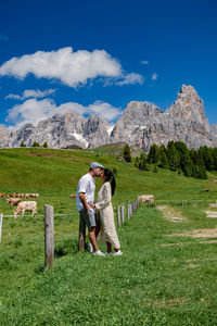 Woman standing on field against mountains