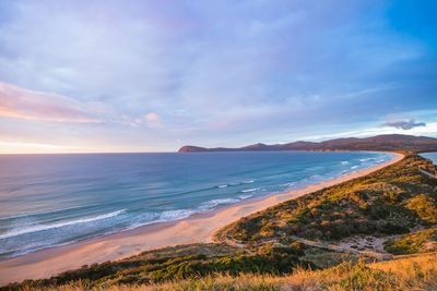 Scenic view of beach and sea against cloudy sky 