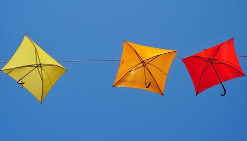 Low angle view of umbrella against blue sky