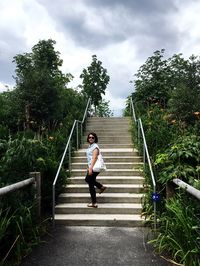 Woman moving on steps amidst plants at park