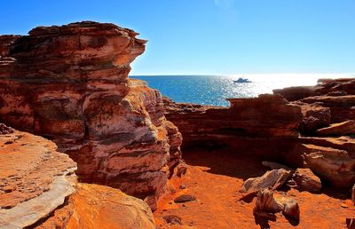 Scenic view of sea from rock formations in roebuck bay against clear blue sky